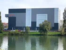 Vue panoramique du CETIC depuis la Saône — bardage bicolore neuf et logo Framatome, projet livré